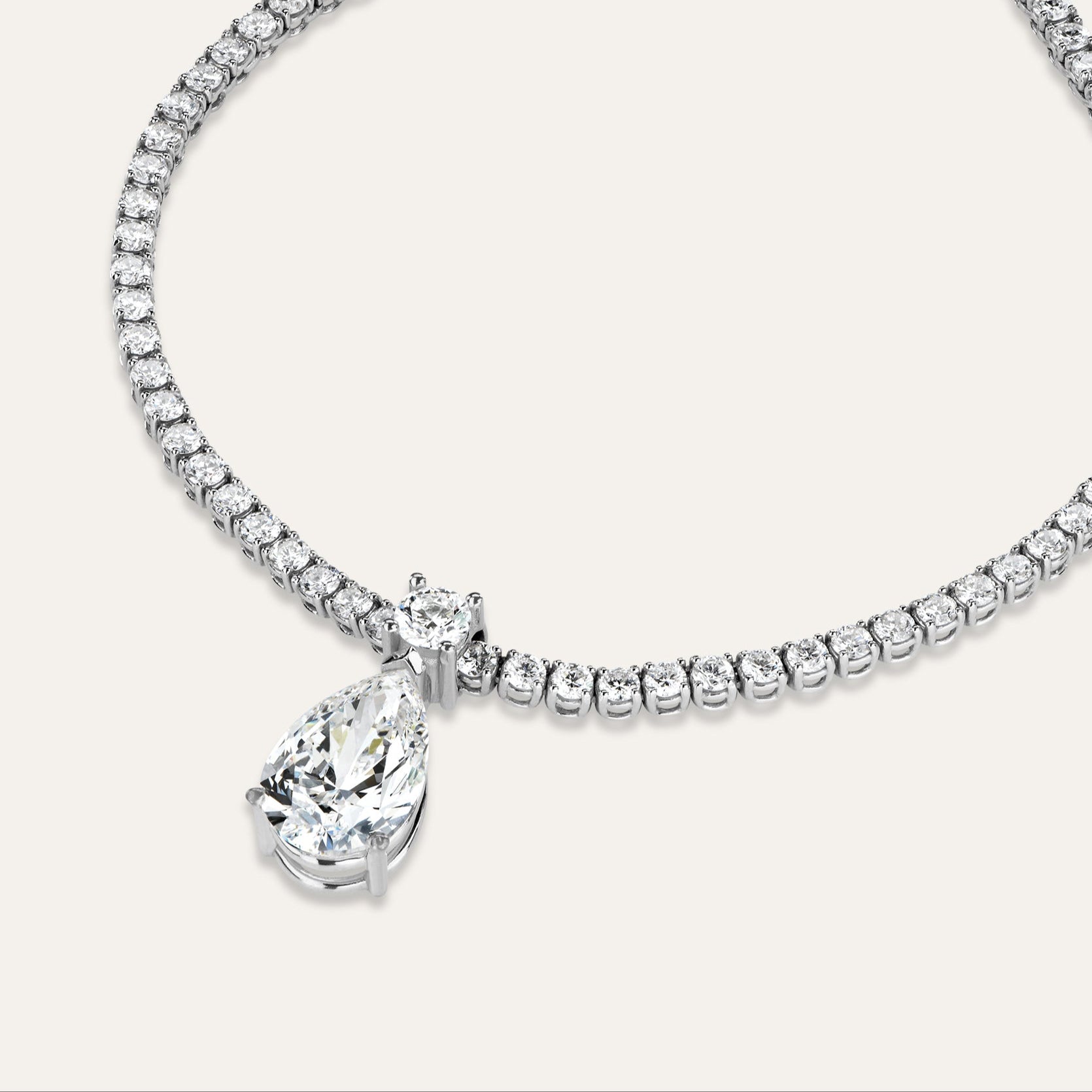 Diamond necklace with a pear shaped pendant on a white background